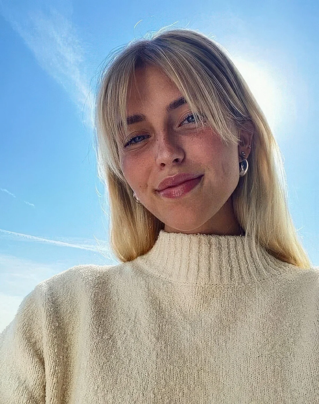 Long blonde hair paired with curtain bangs.