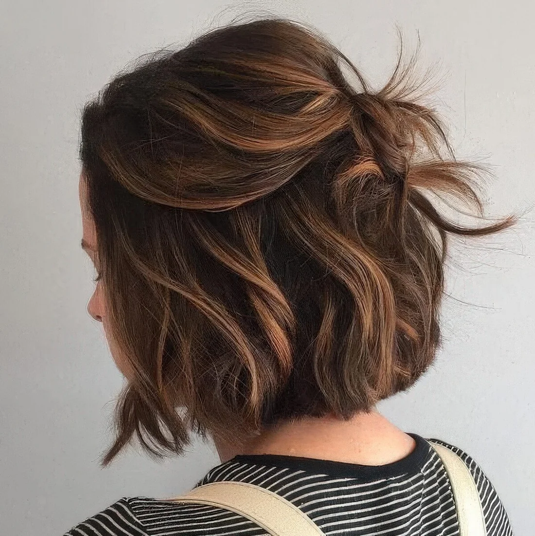 Black bob done with caramel balayage, with a lot of volume, waves.