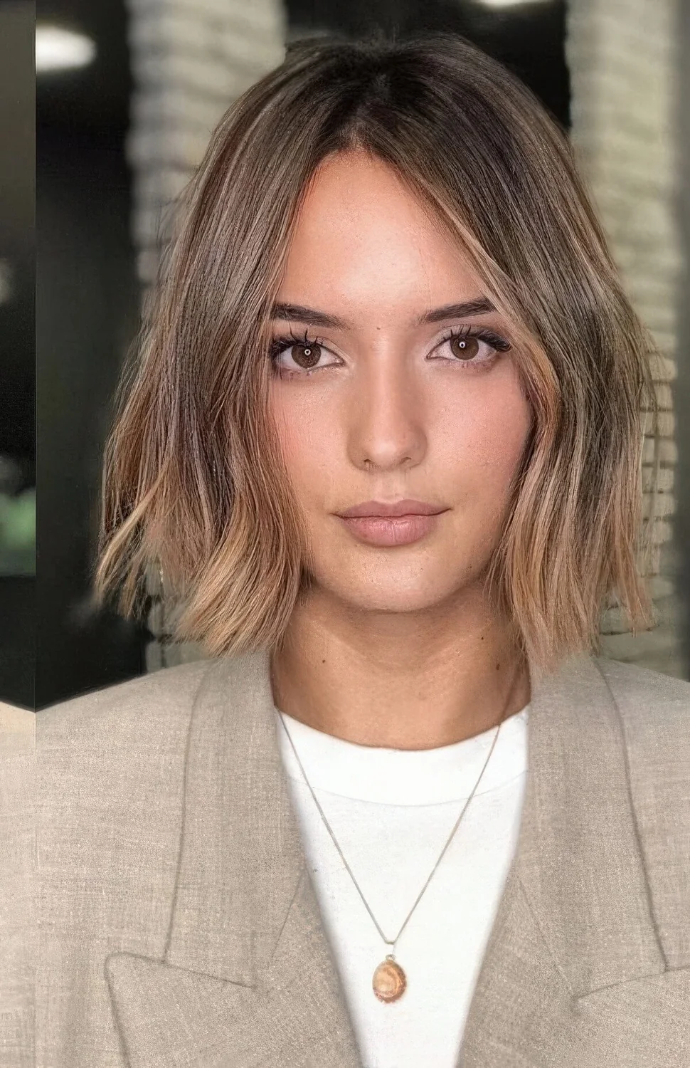 Brown bob with darker root and caramel and gold balayage, with irregular parting and slight waves.