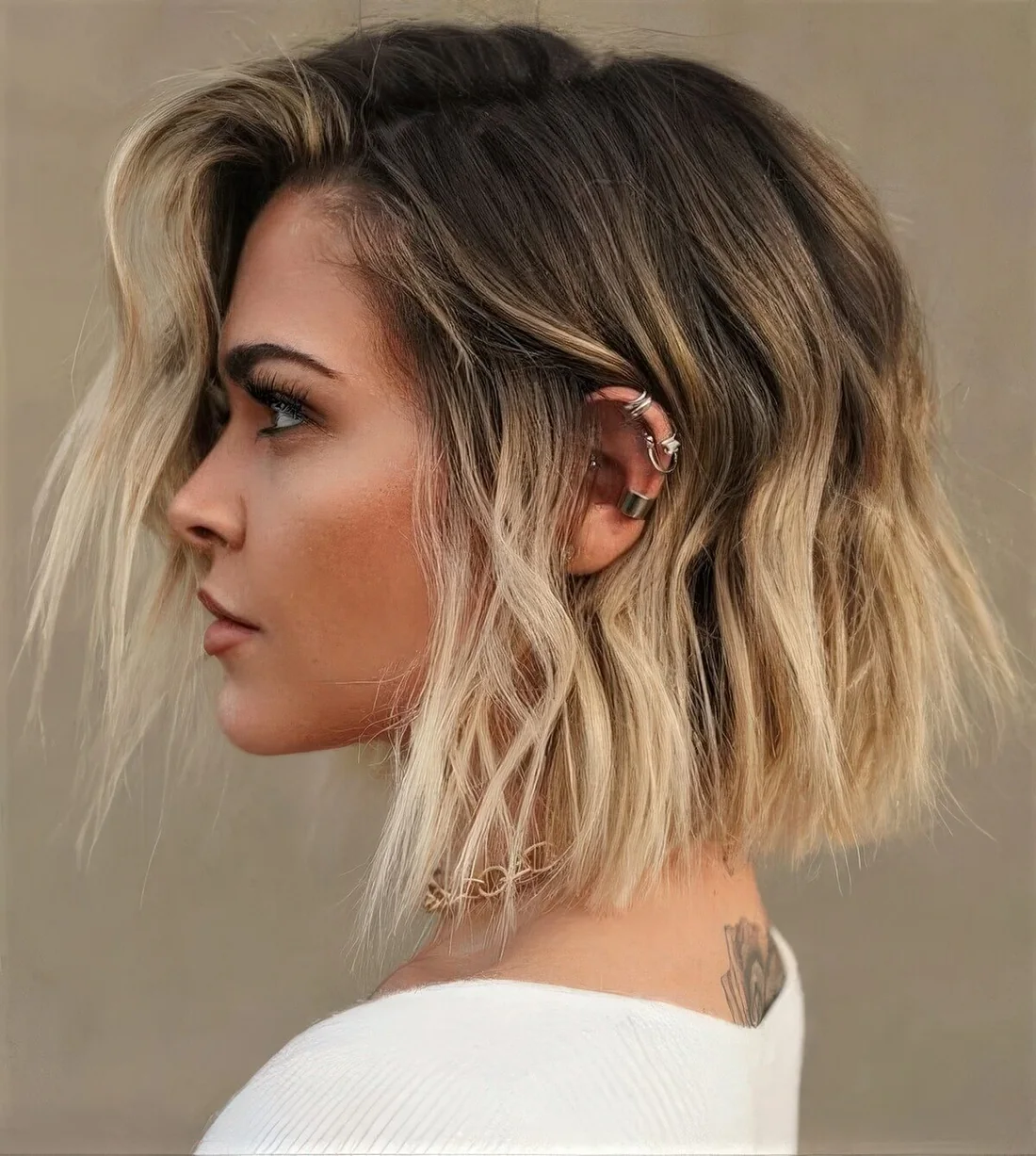 Long bob with a darker root and blonde balayage and waves plus much volume.