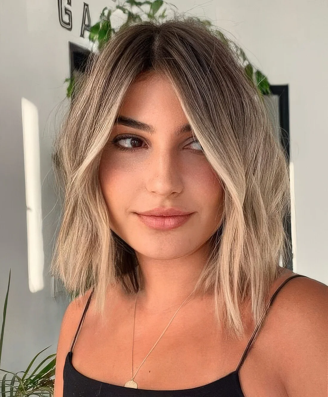 Long bob with darker root and blonde balayage plus messy waves.