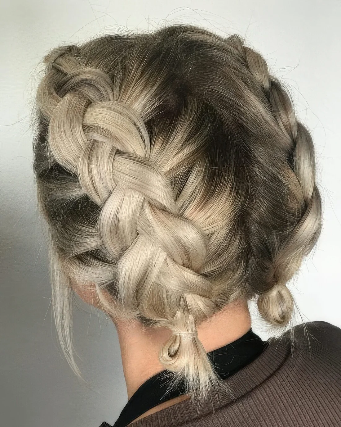 Short hair done with two milk braids ending with little buns.