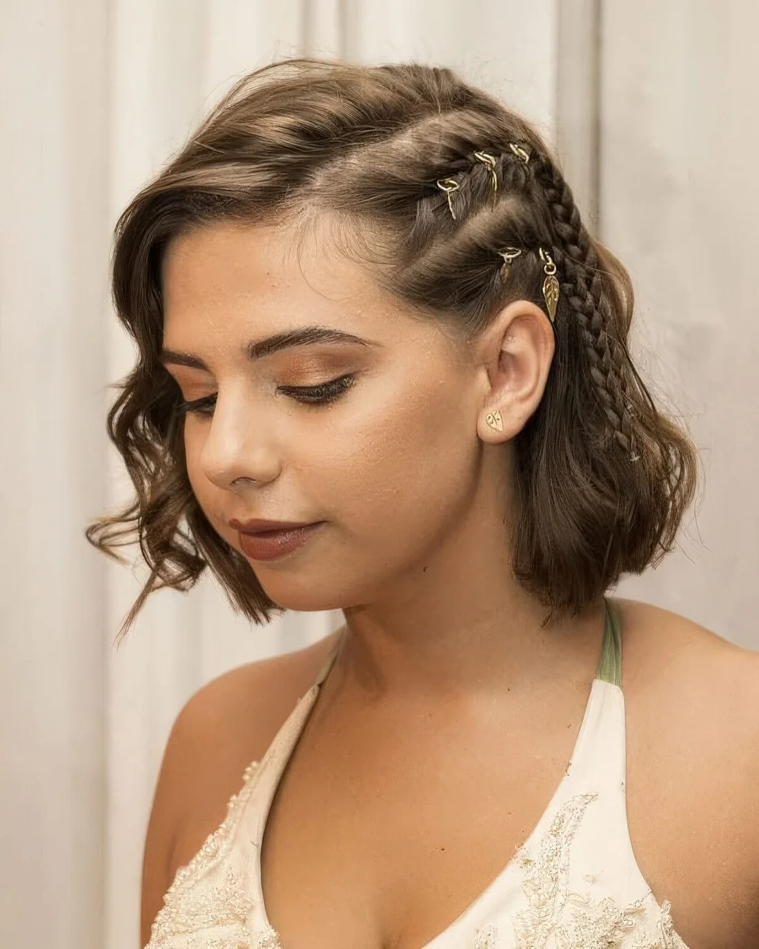 Boho half updo with a side braid and hair piercings and waves down.