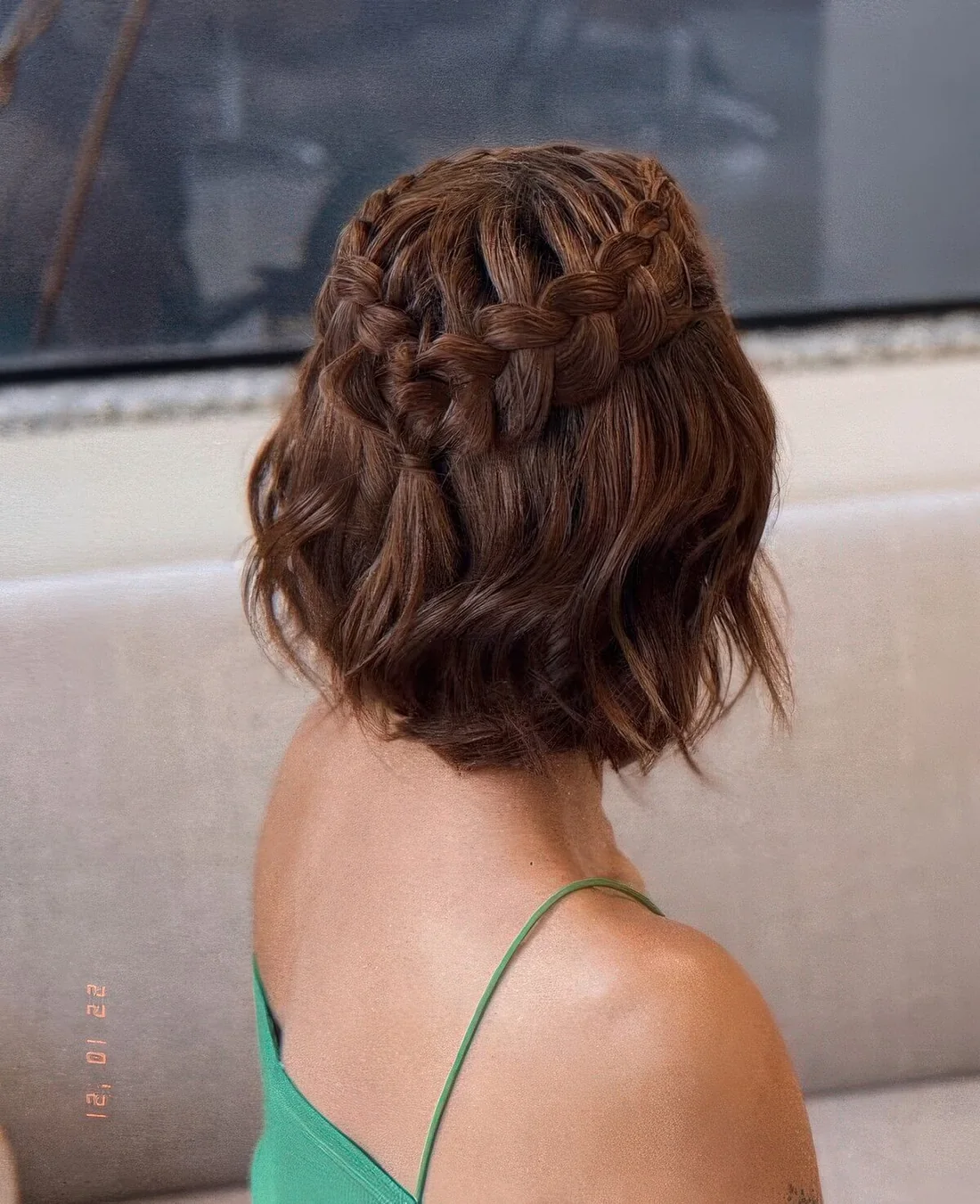 Half updo with a loose braided halo and waves down.