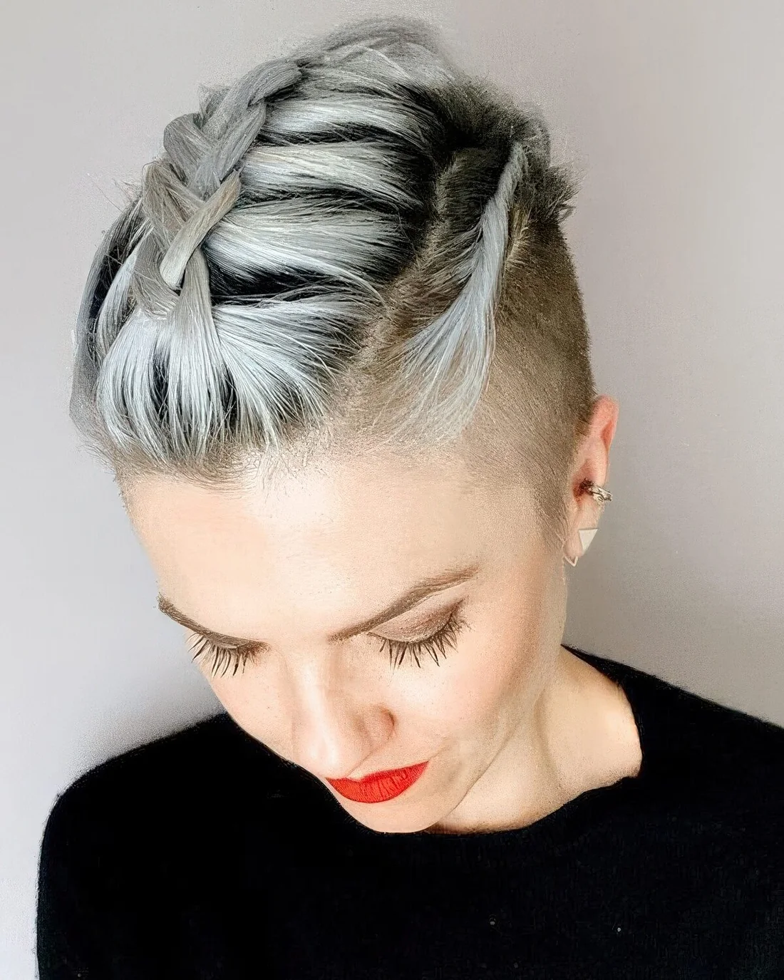 Long grey pixie haircut done with a braid on top.