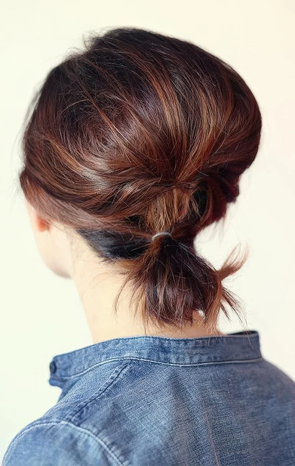 Low ponytail with a bump secured with a bobby pin.