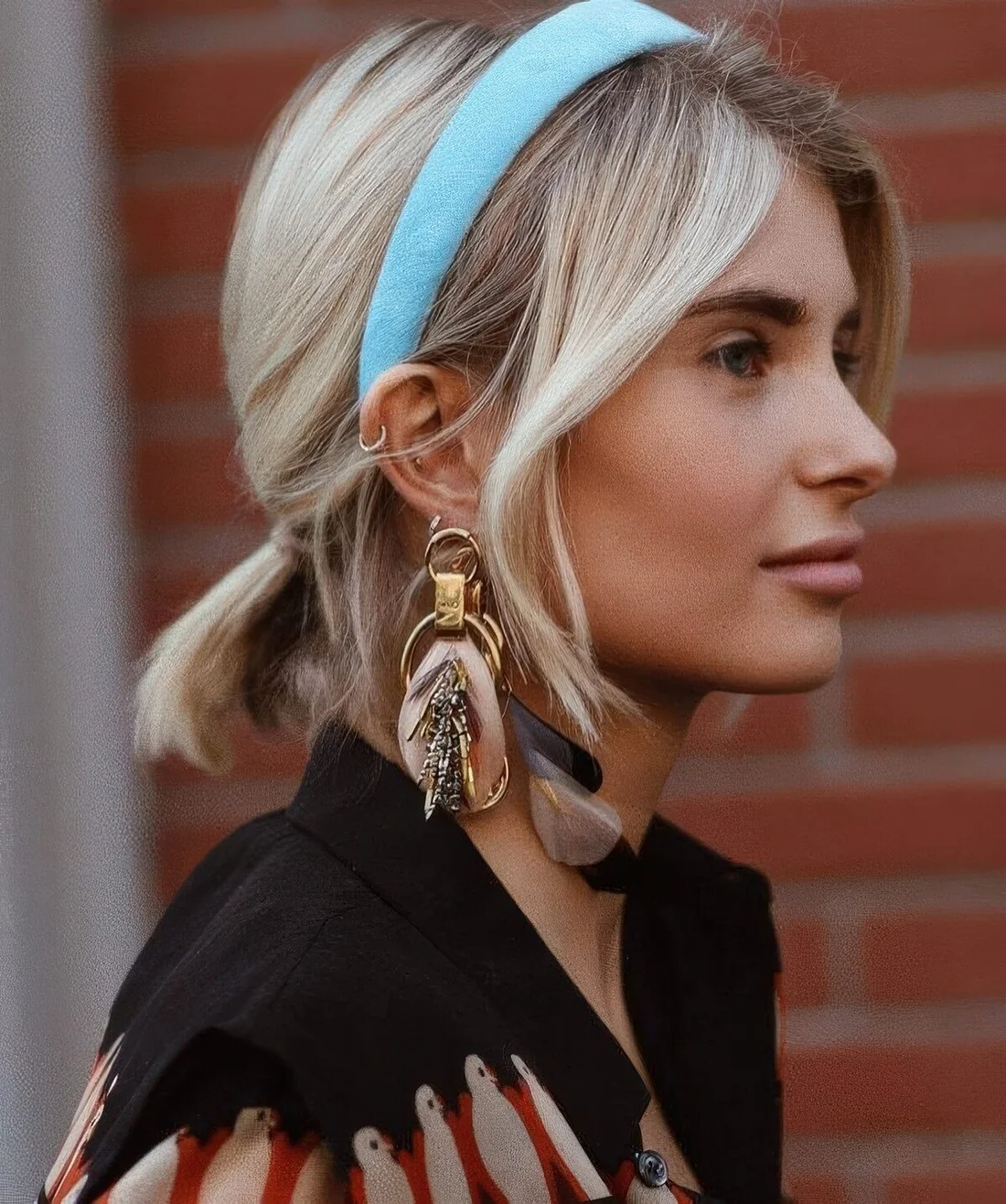 Low relaxed ponytail with side bangs and a blue headband.
