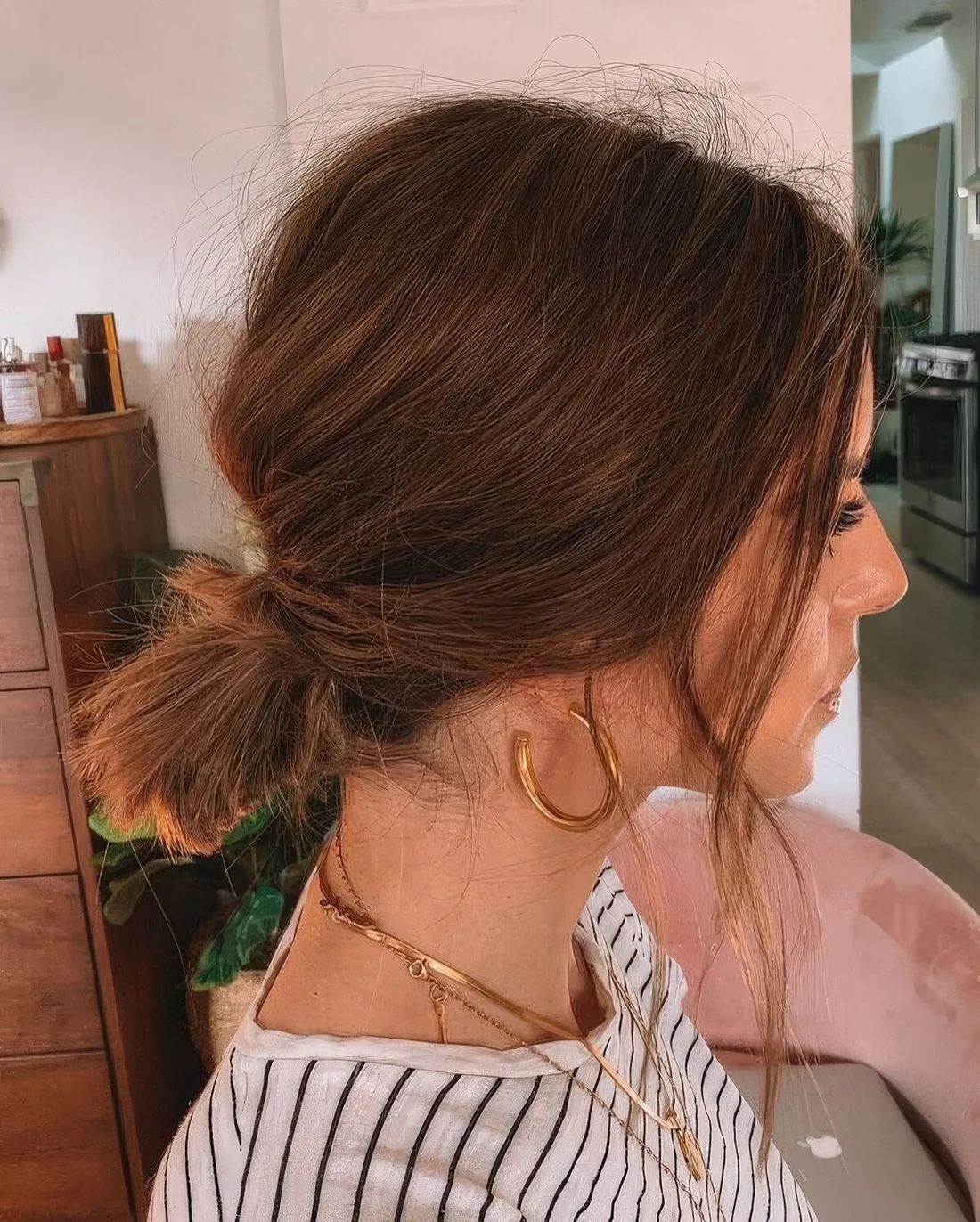Midi brunette bob with a low ponytail and a bump on top plus some face-framing hair.
