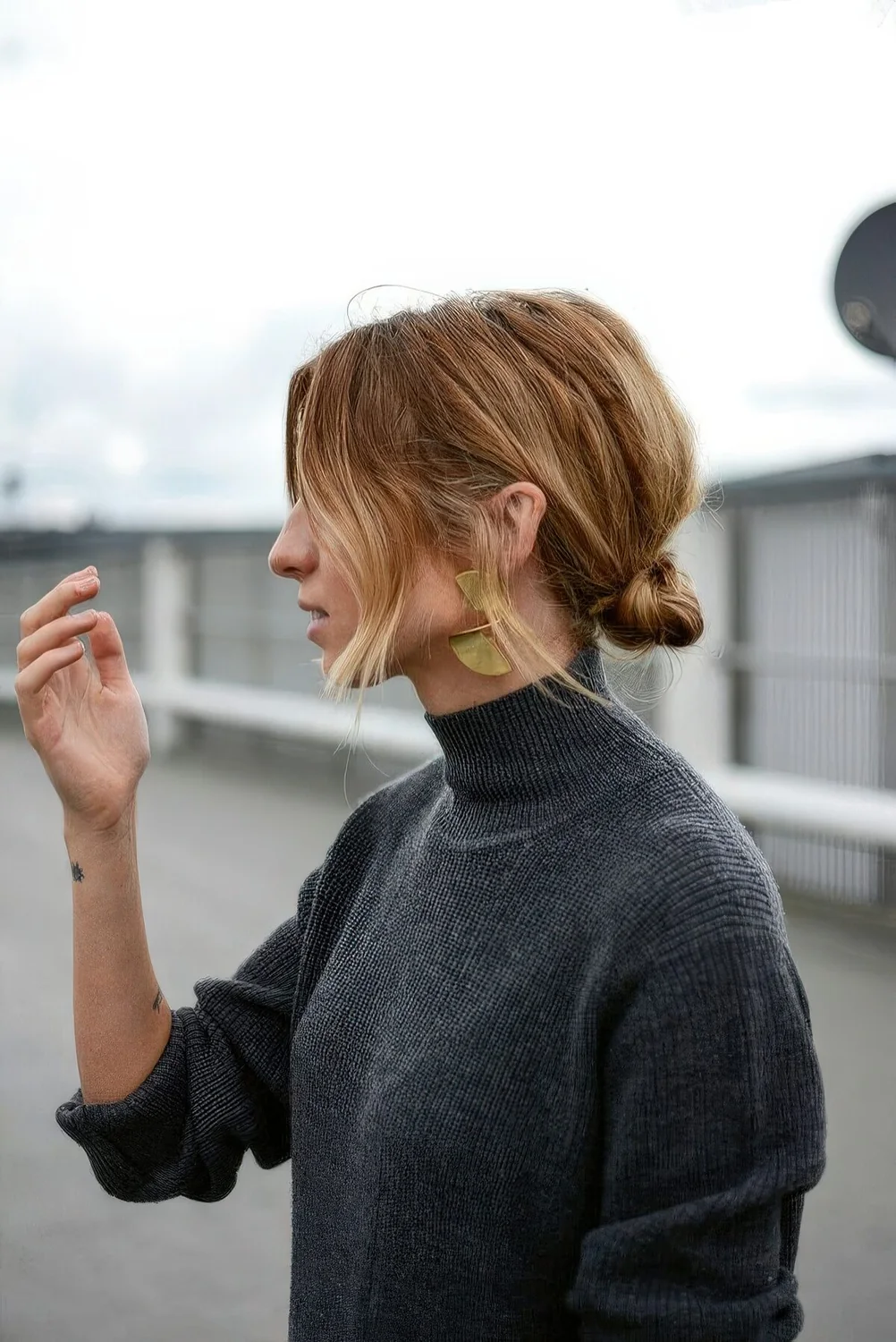 Messy knotted low bun with some volume on top and face-framing hair.