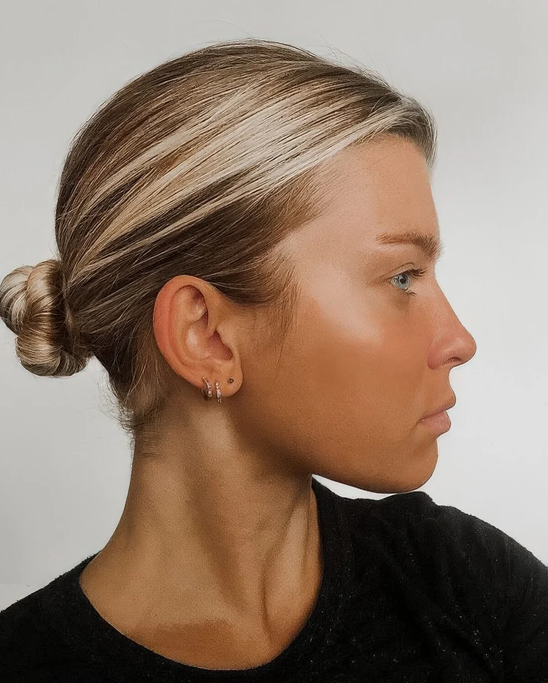 Photo showing low ballerina bun and a sleek top, with the hairstyle clearly visible.