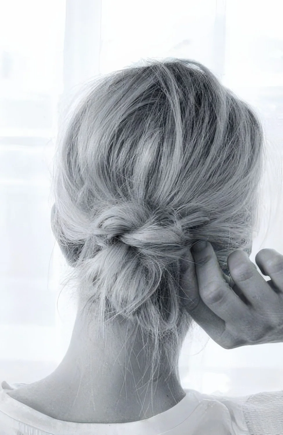 Messy low bun with a messy top and a knot.
