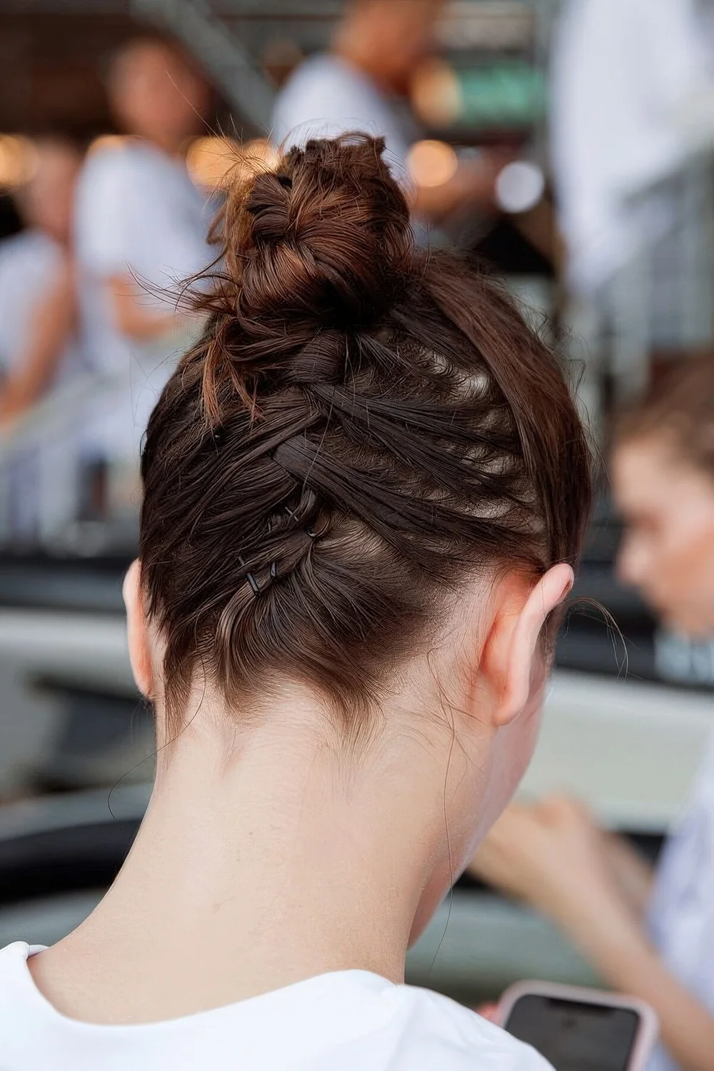 Top knot with hair secured up with bobby pins.