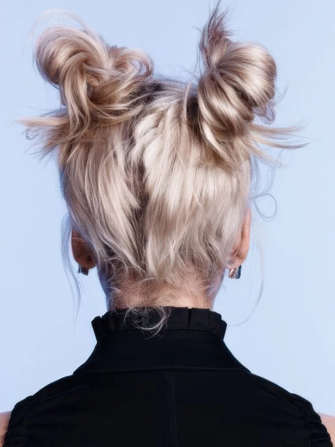 Messy space buns on strawberry blonde hair, with mess around.