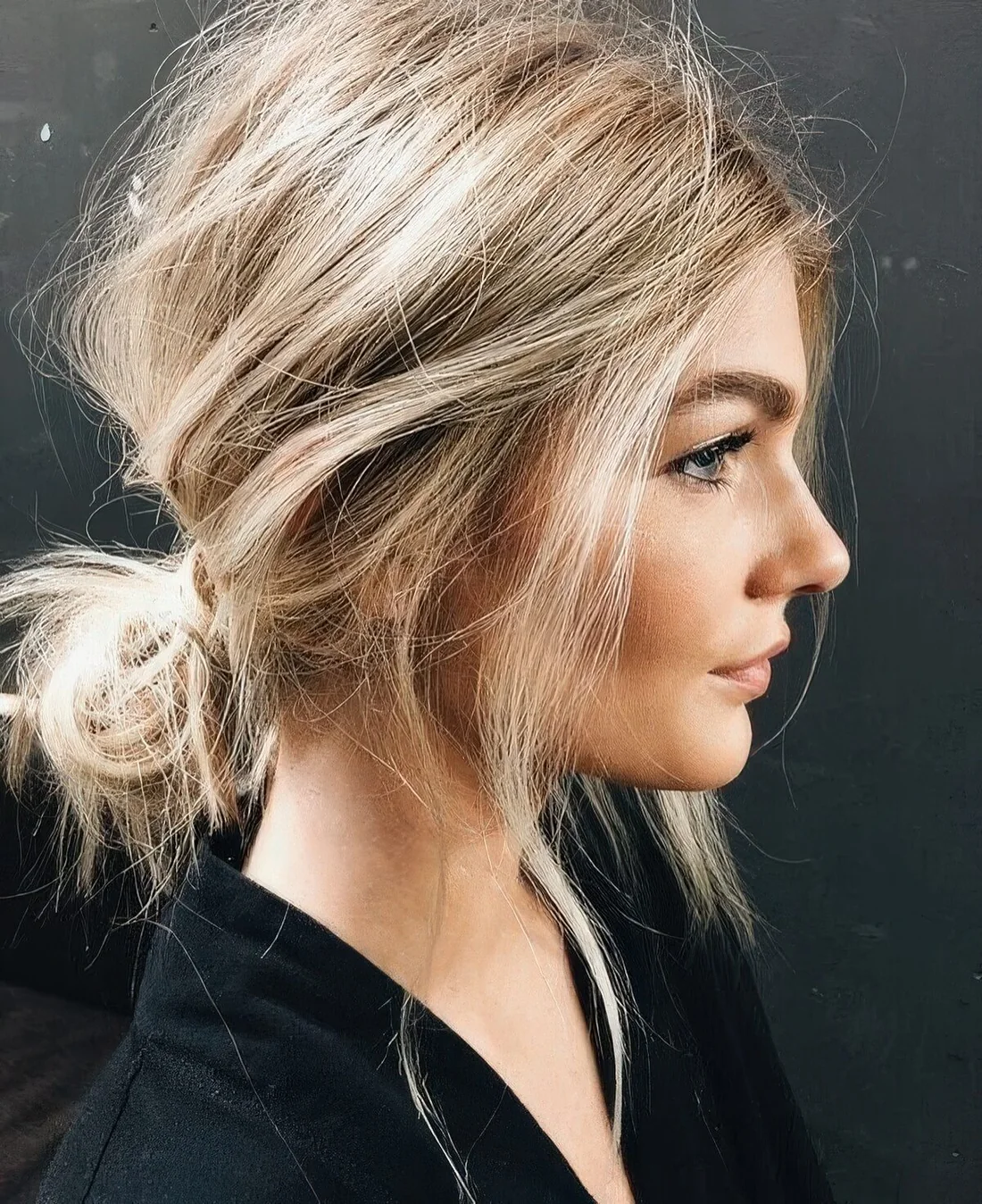 Messy low updo with a messy top and face-framing hair.