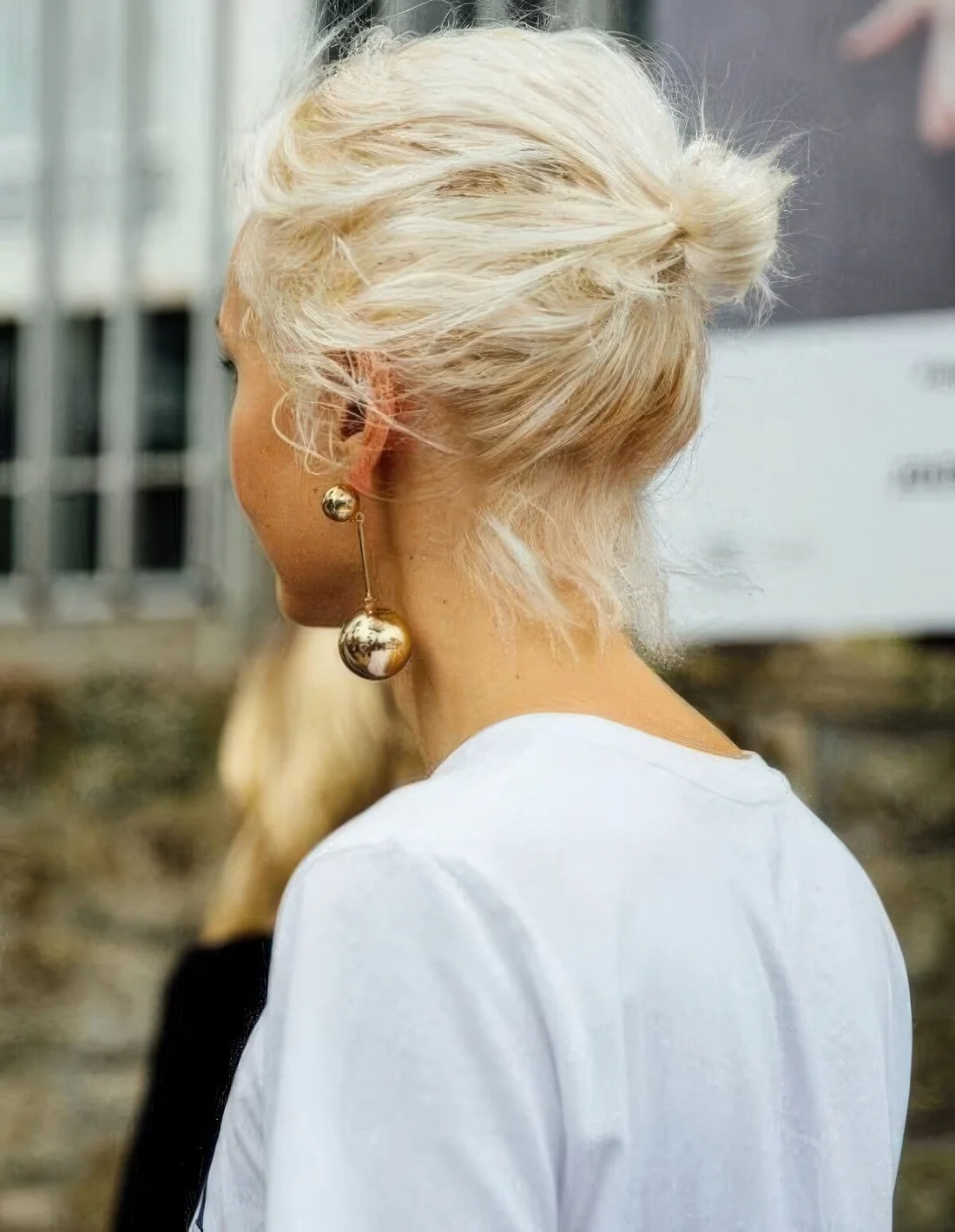 Photo showing messy midi bun with a messy top, with the hairstyle clearly visible.
