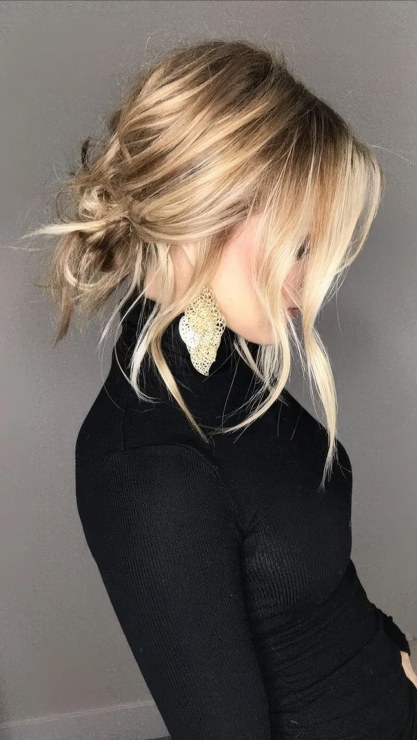 Messy and chic low bun with a bump on top and face-framing hair.