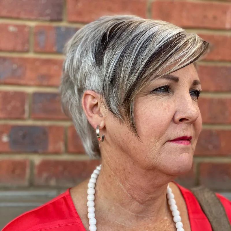 chin straight silver pixie with side swept fringe shown as a short haircuts for women over 70 idea, featuring volume through the ends