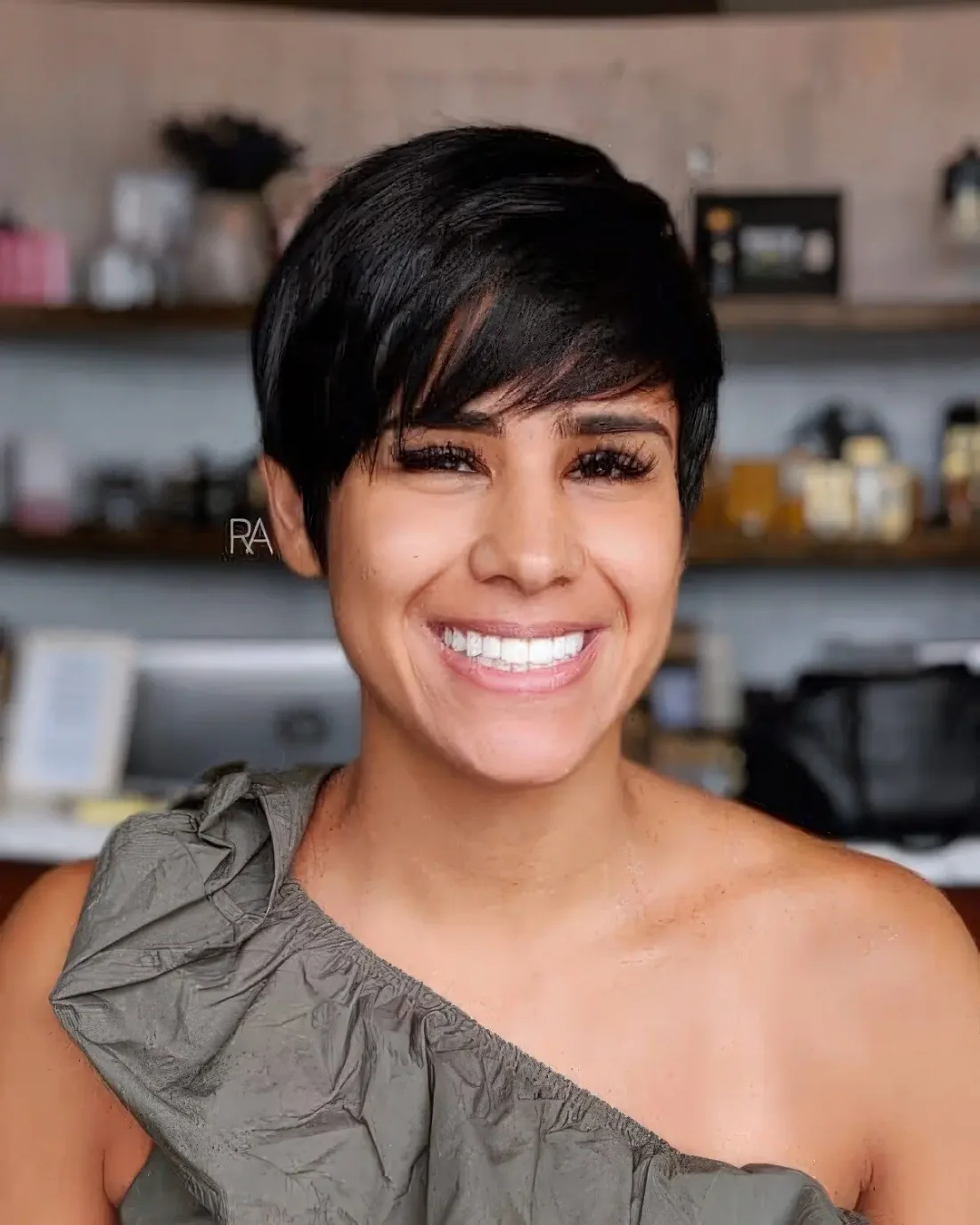 Black pixie haircut with long side swept bangs.