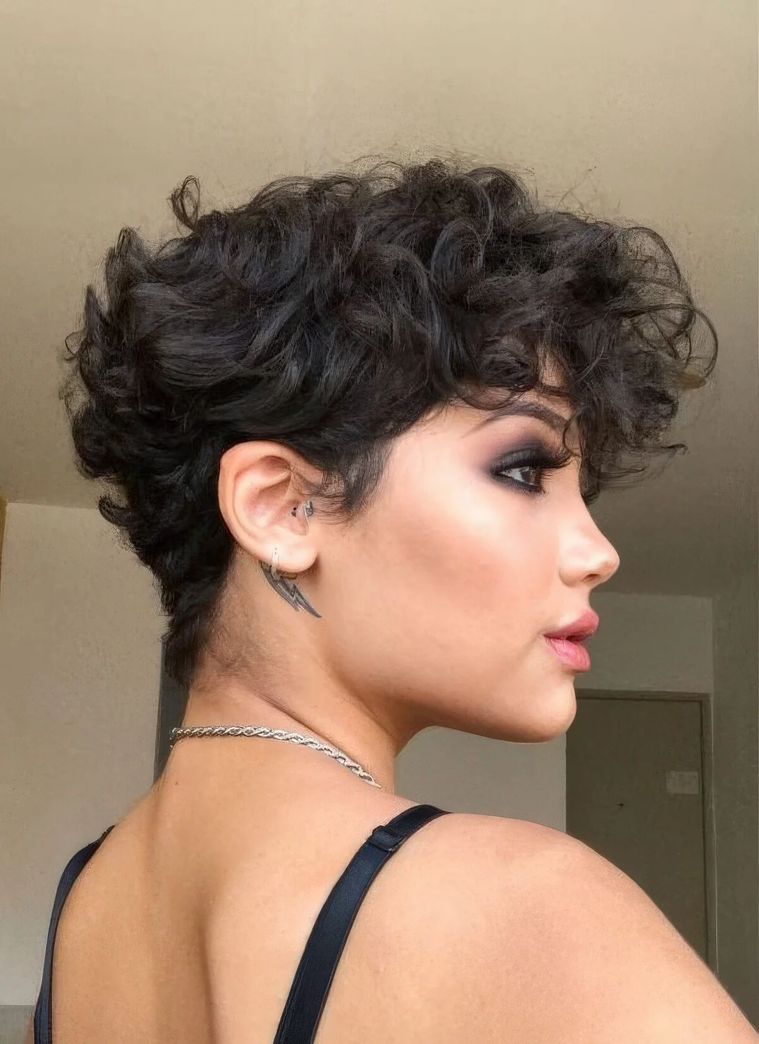 Black wavy pixie with a lot of volume and longer bangs.