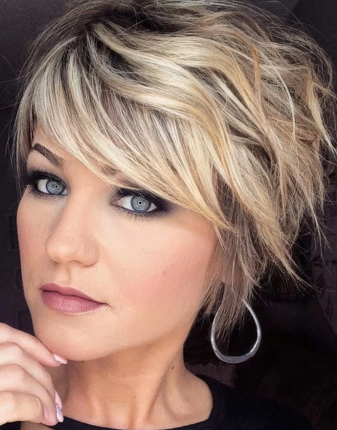 Blonde layered and shaggy pixie haircut with a darker root.