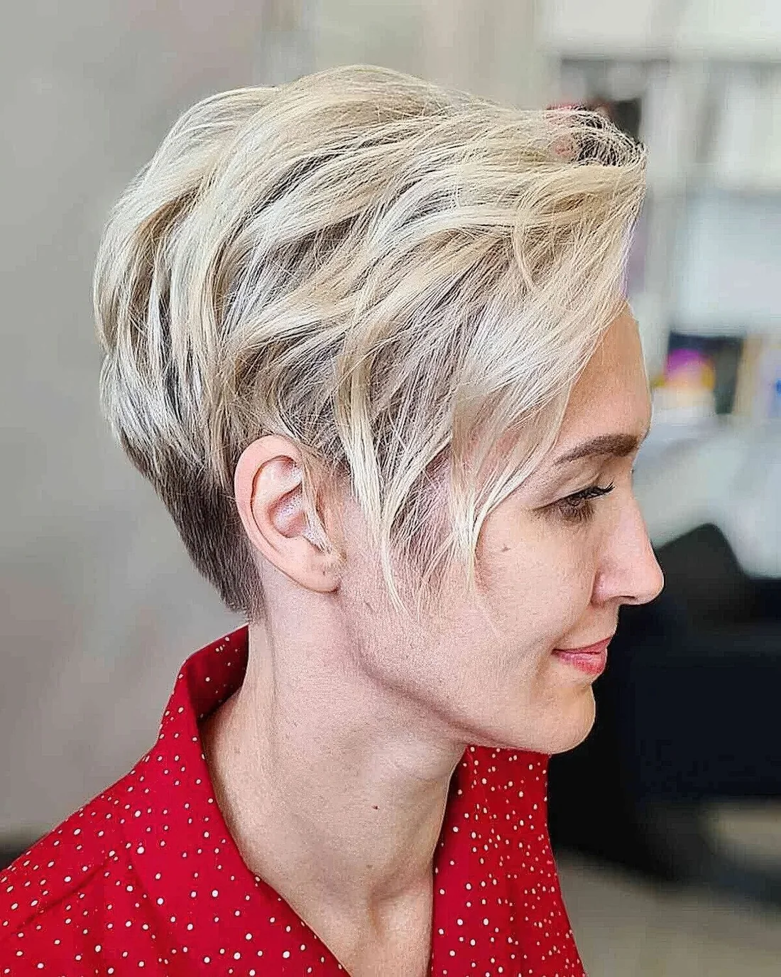 Pixie with blonde balayage and long side bangs, waves and dimension.