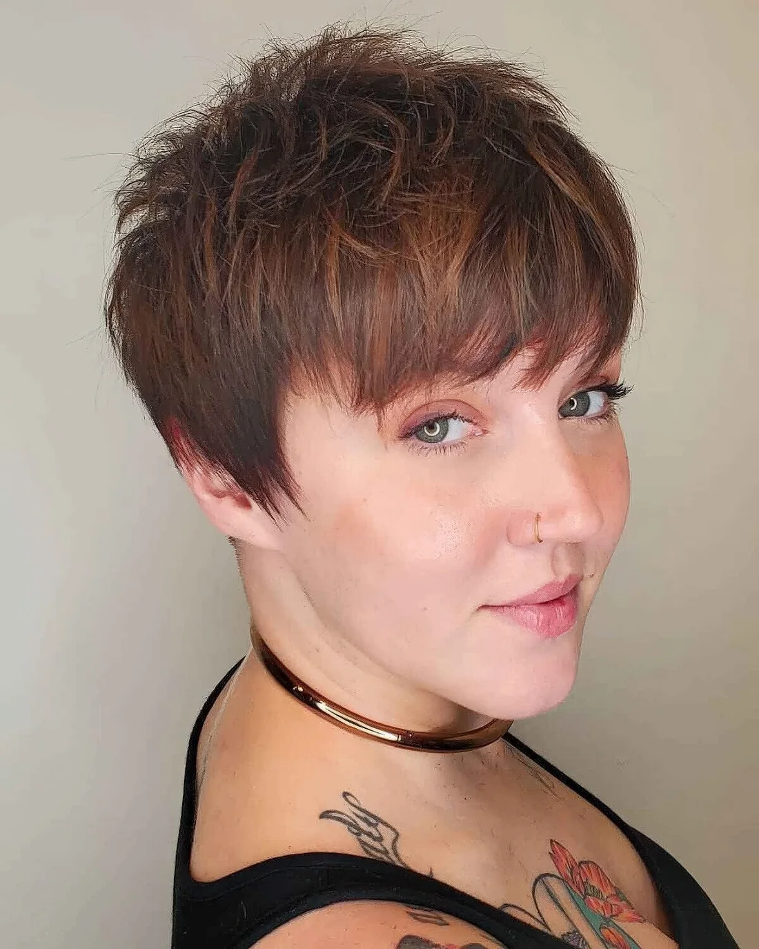 Burgundy pixie haircut with layers and long bangs plus long sides.