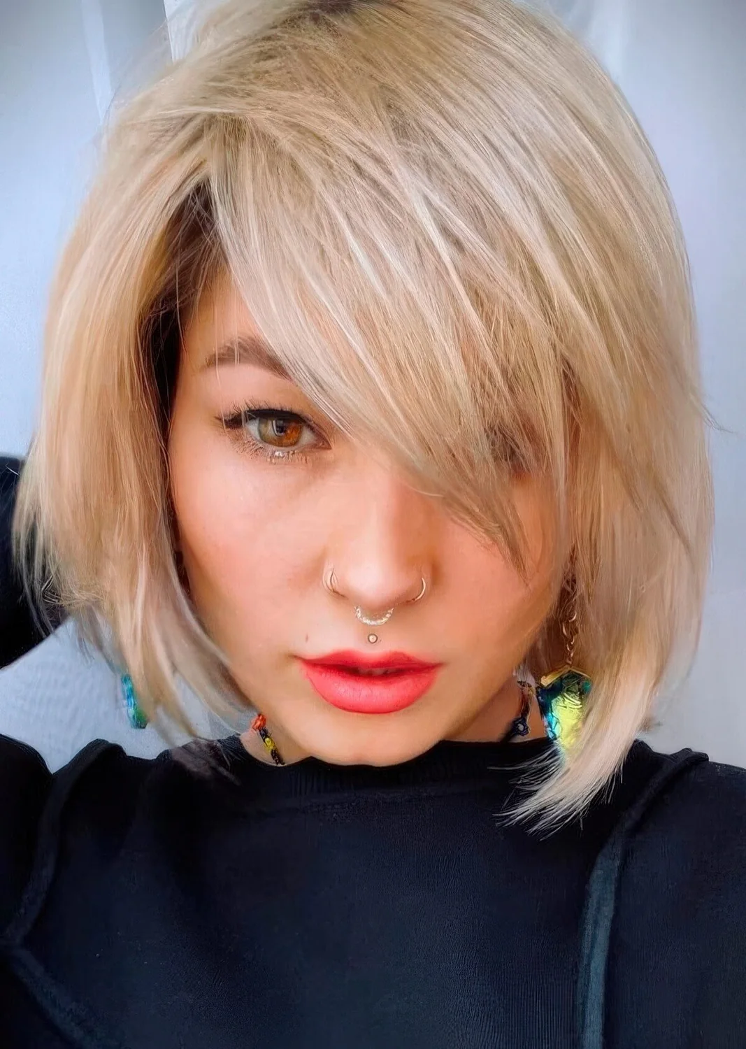 Chin-length creamy blonde bob with side bangs and plenty of movement and texture.