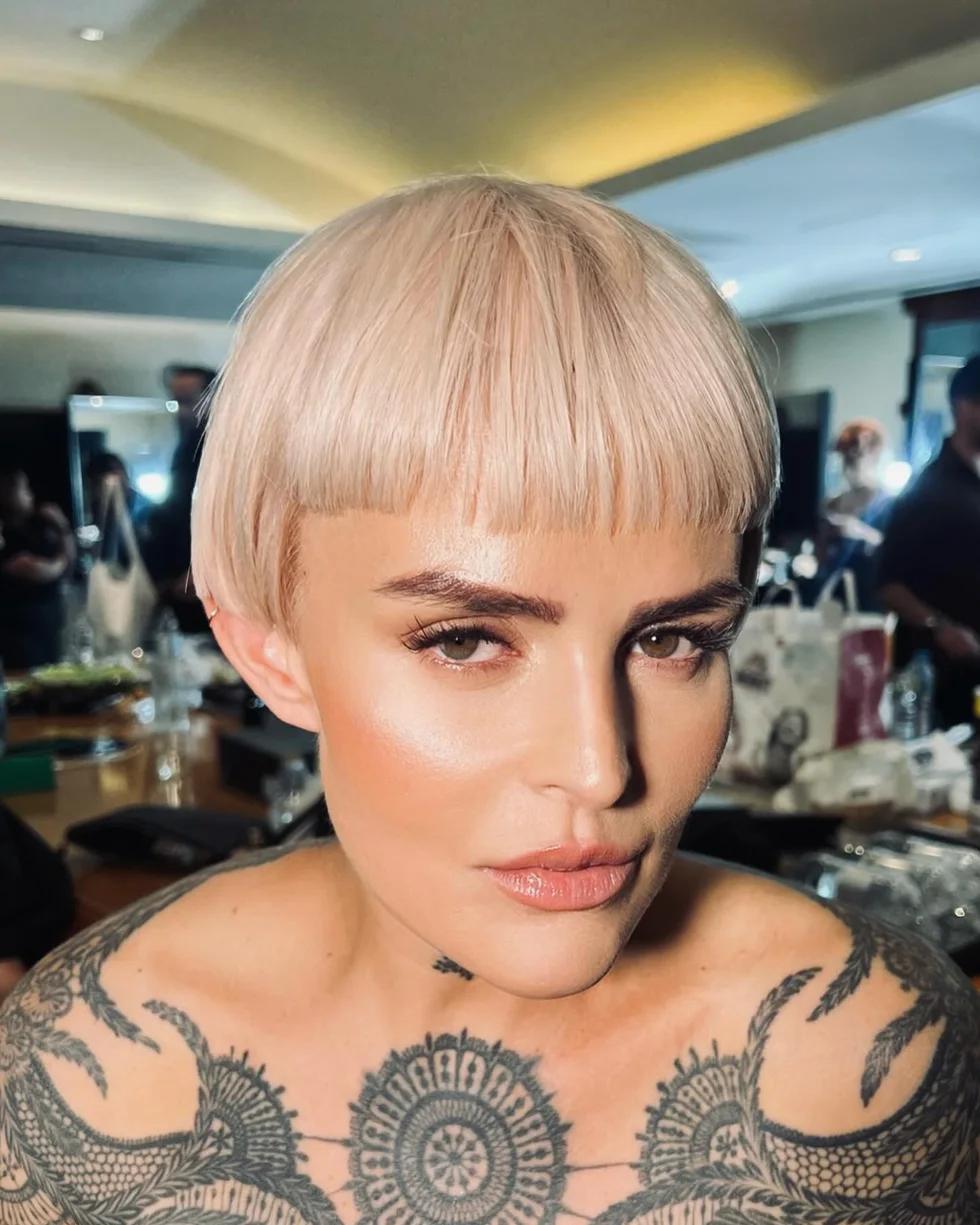 ear straight chestnut pixie with side swept fringe shown as a short hairstyles for thin hair and round face idea, featuring side swept fringe