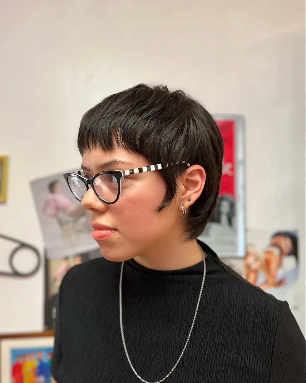ear straight chestnut pixie with side swept fringe shown as a short hairstyles for thin hair and round face idea, featuring ear outline, shown in dark micro pixie with glasses