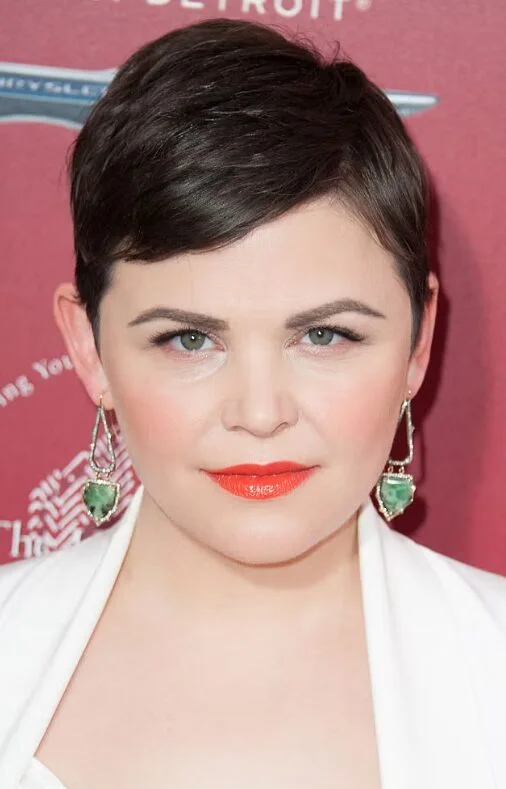 ear straight chestnut pixie with side swept fringe shown as a short hairstyles for thin hair and round face idea, featuring side swept fringe, shown in black tapered side-part pixie