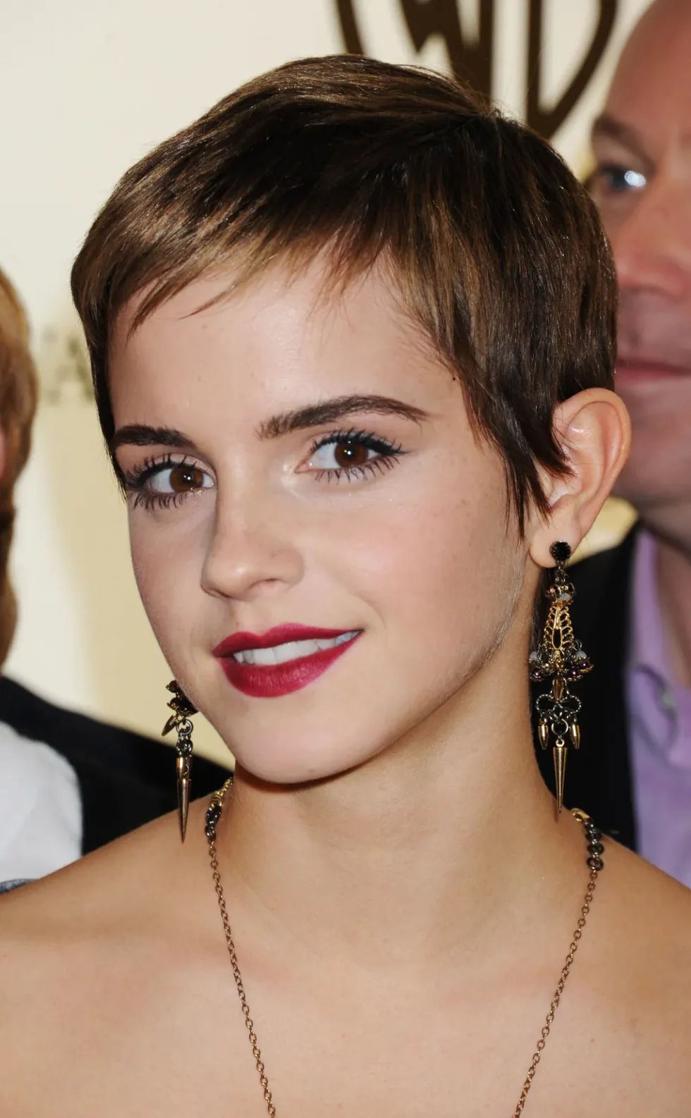 ear straight chestnut pixie with side swept fringe shown as a short hairstyles for thin hair and round face idea, featuring wet look finish