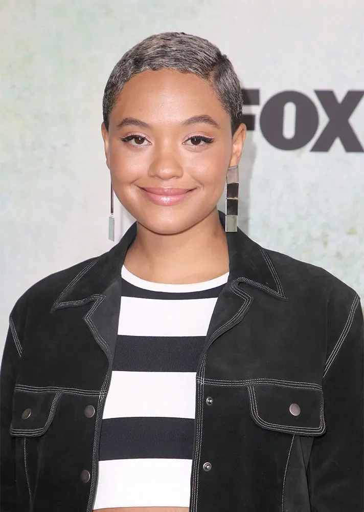 ear straight chestnut pixie with side swept fringe shown as a short hairstyles for thin hair and round face idea, featuring volume through the crown, shown in close black pixie crop