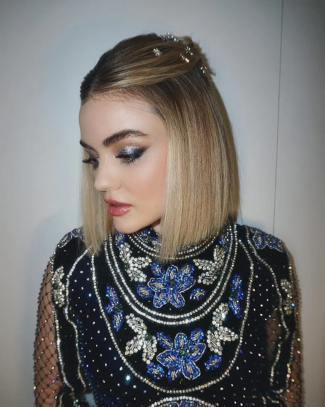 Blonde long bob styled as a half updo and with star hair pins.