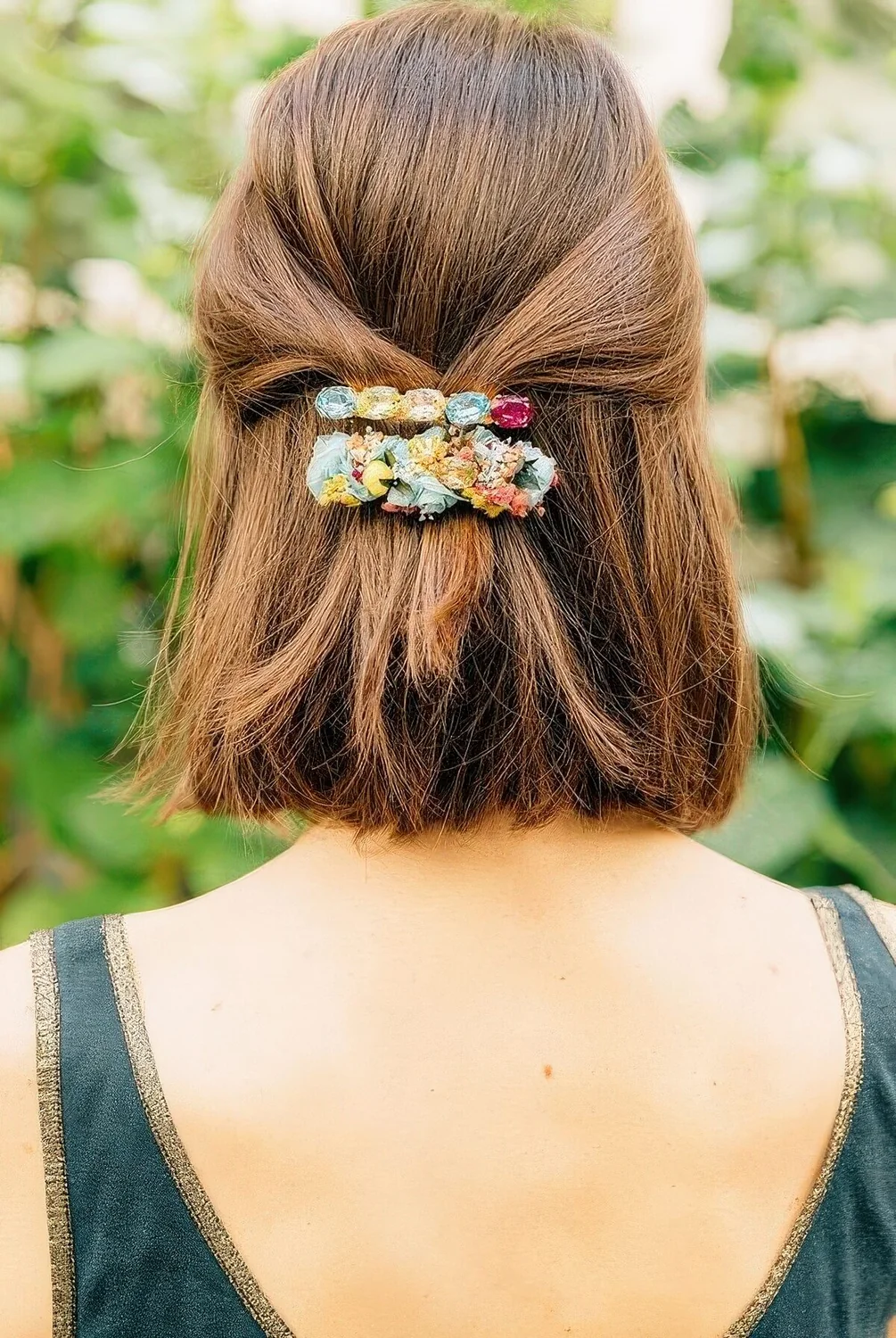 Half updo with straight volumetric hair and colorful barrettes.