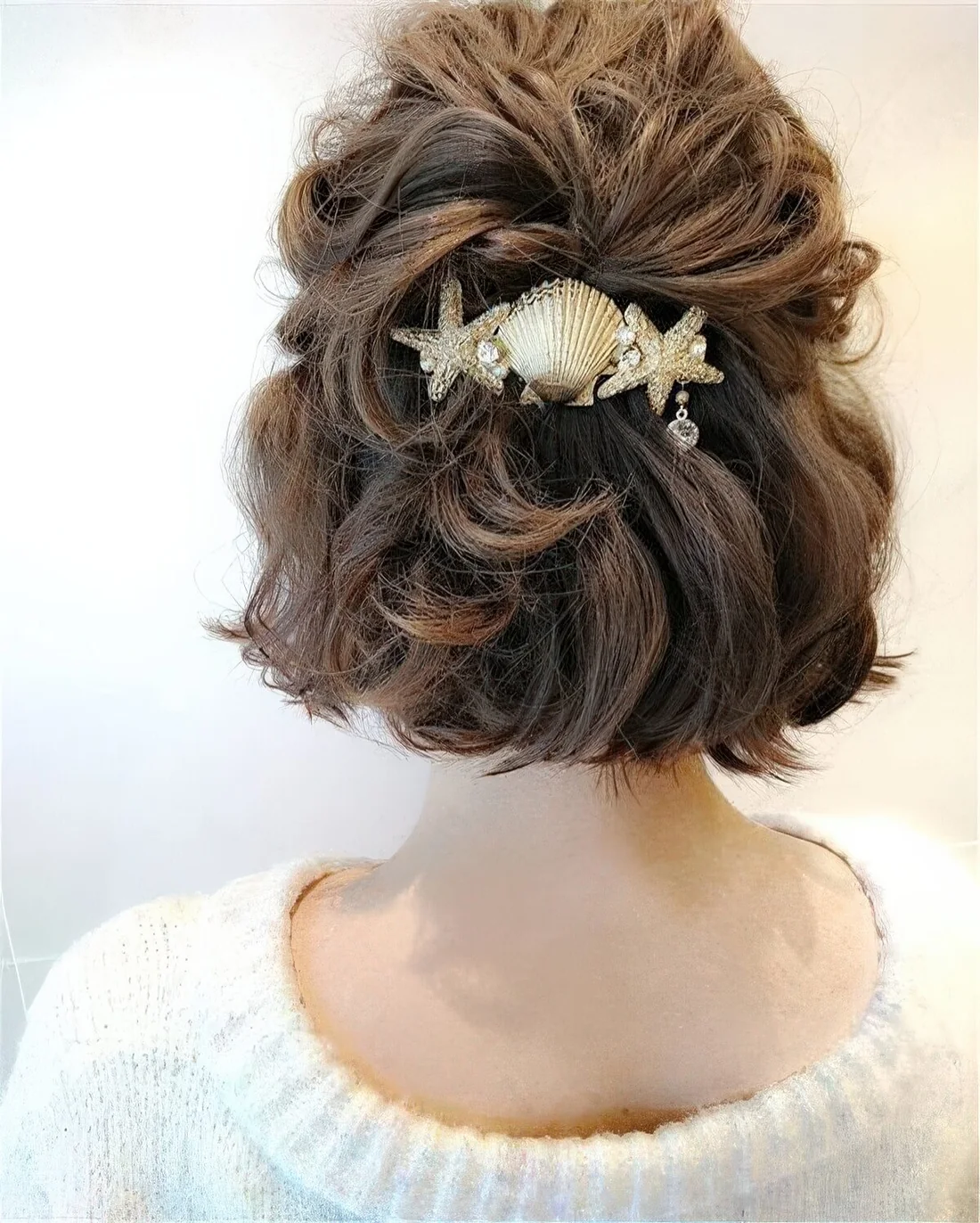 Half updo with a wavy top and waves down plus a lovely coastal hair piece.