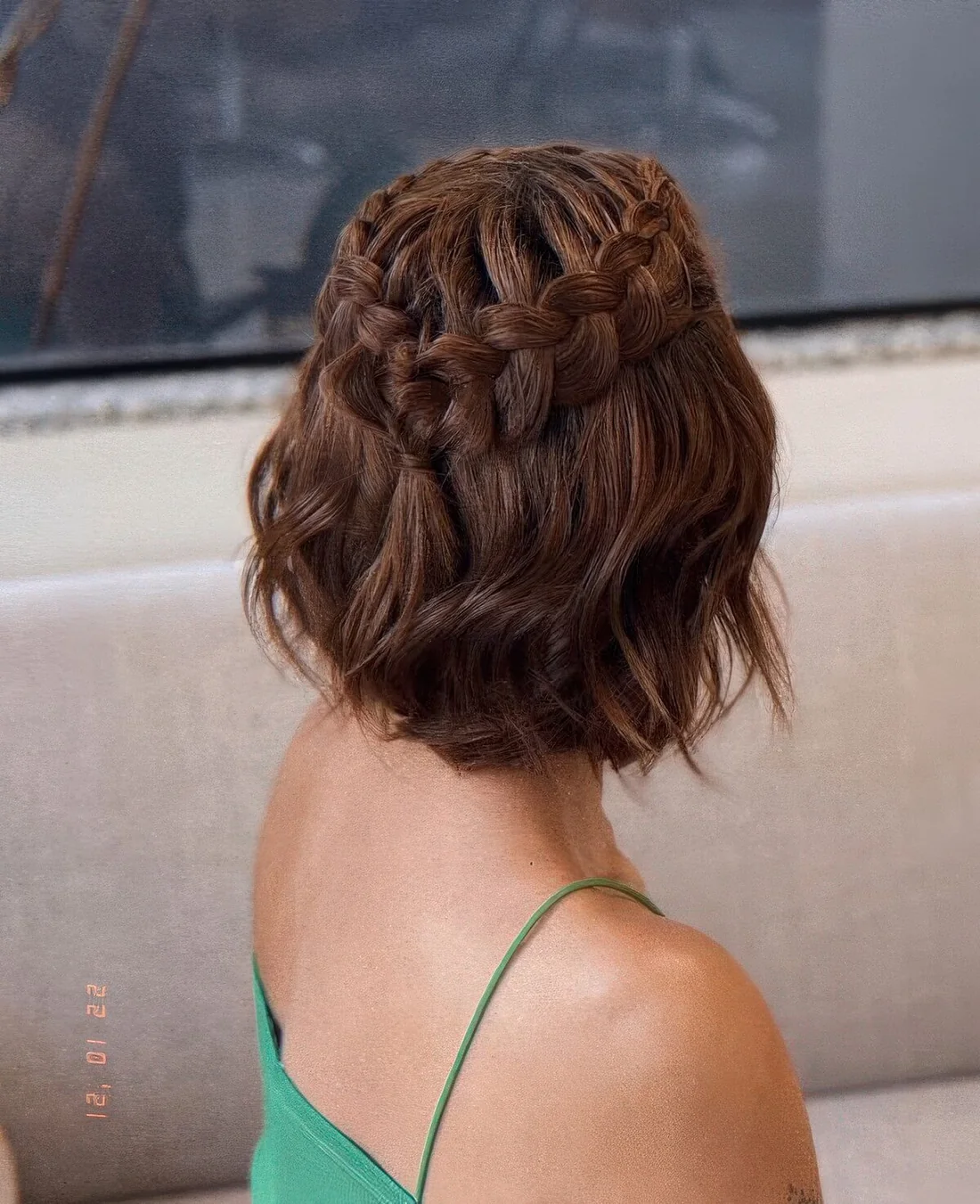 Half updo with a loose braided halo and waves down.