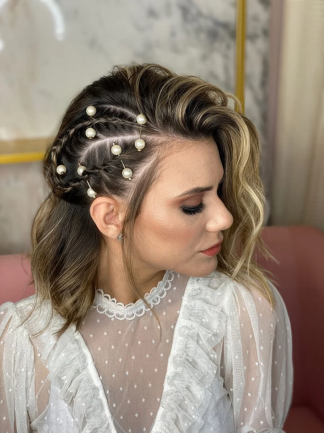 Long blonde bob with side braids on one side and waves down on the second plus pearl hair piercings.