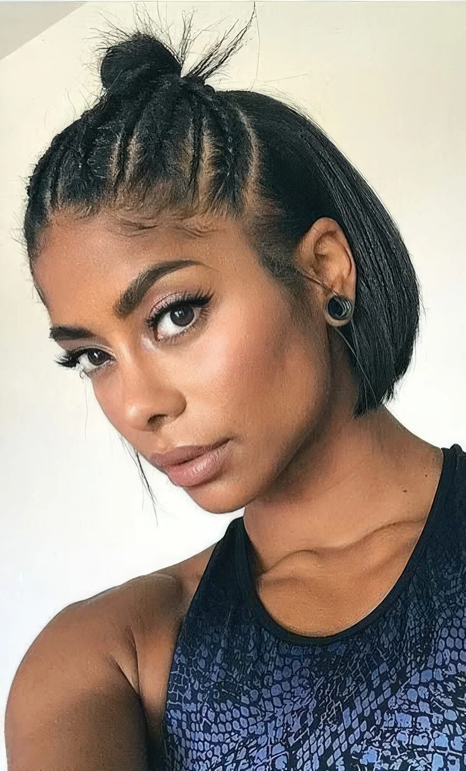 Half updo with several small braids on top and a top knot plus hair down.