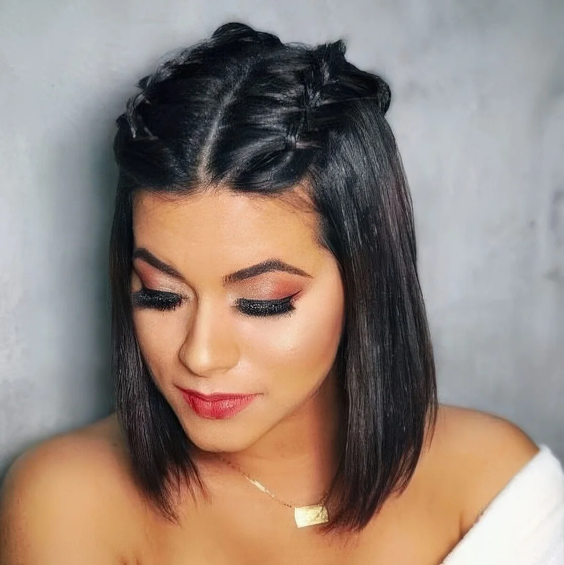 Long black bob with straight hair and two braids on top.
