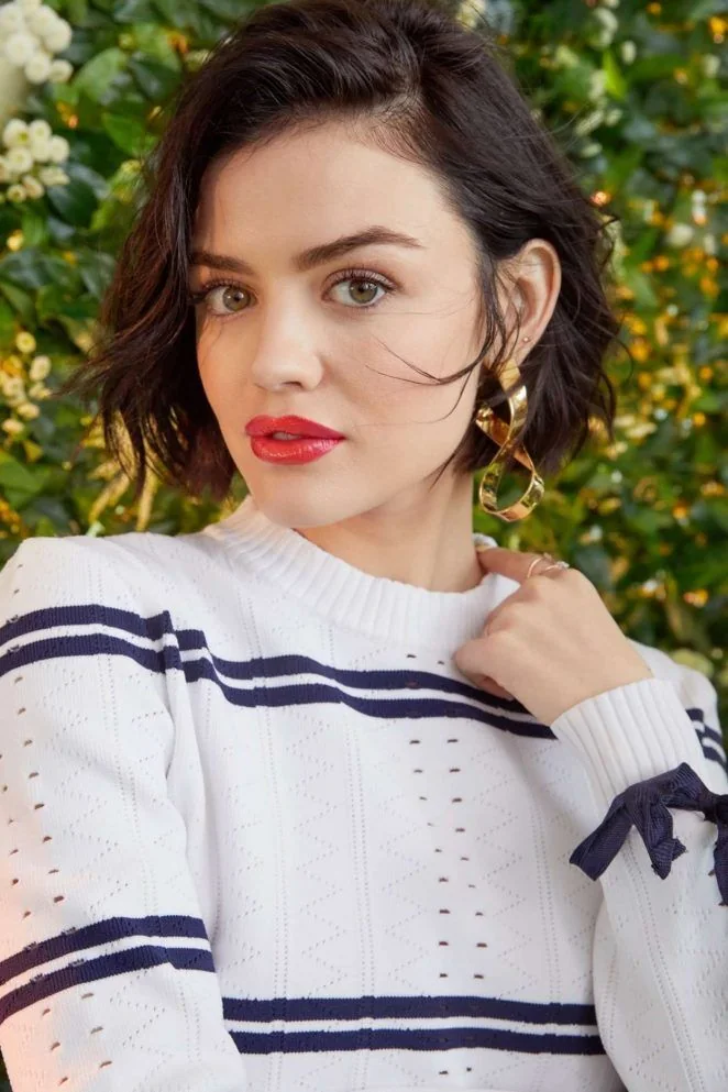 A short brunette bob is swept to one side with soft waves and an open opposite temple