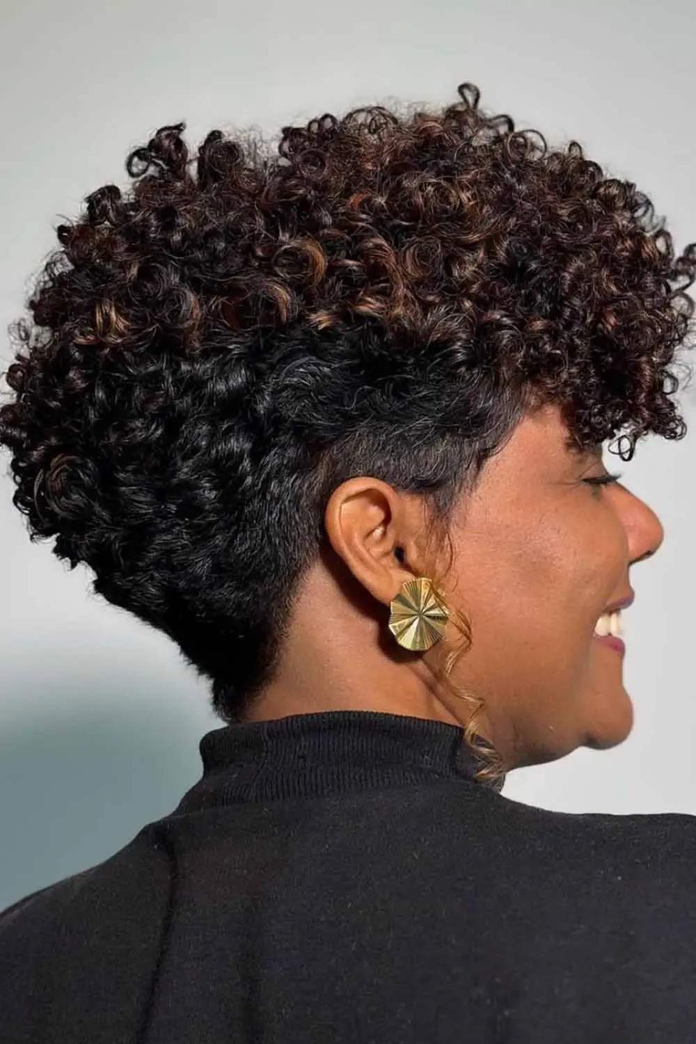 ear coily black curly style shown as a short natural hairstyles for black women over 50 idea, featuring coily texture, shown in black coily curly style with coily texture with coily texture
