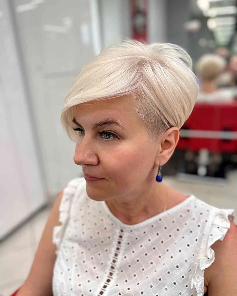ear straight silver pixie with side swept fringe shown as a short pixie haircuts for older women idea, featuring textured finish