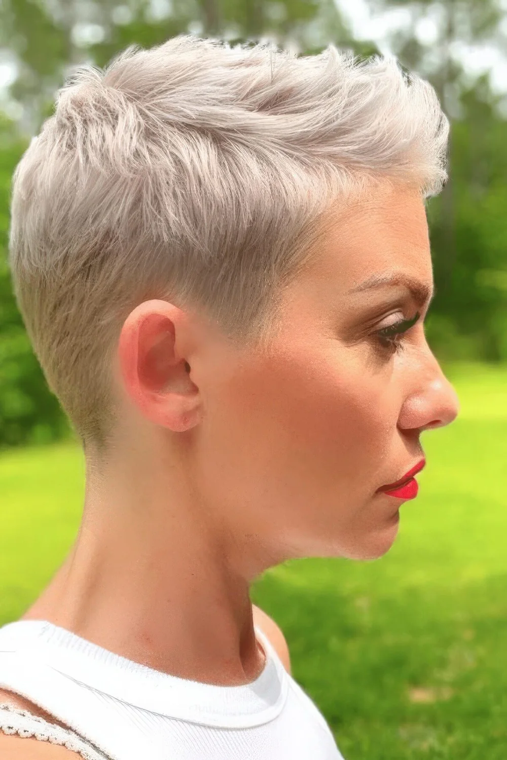 Blonde short pixie haircut with side part and a bit of styling.