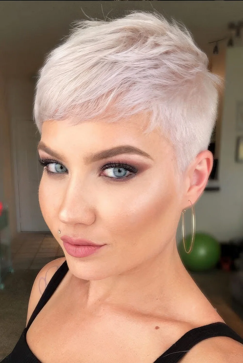 Pale pink short pixie cut with a bit of volume.