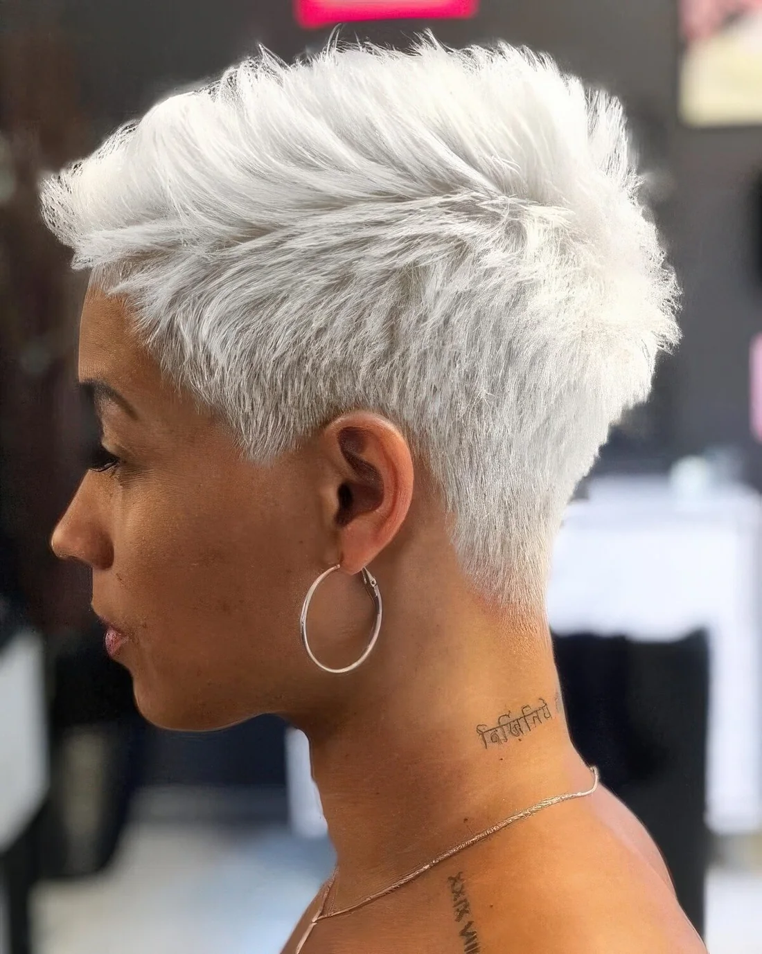 Photo showing icy blonde short pixie, with the hairstyle clearly visible.