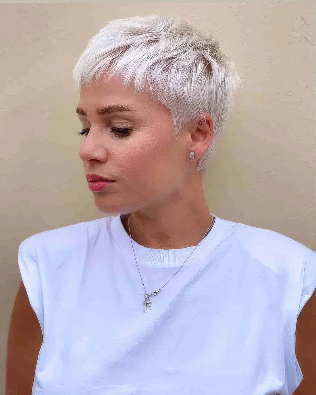 Icy blonde short pixie with textured volume.
