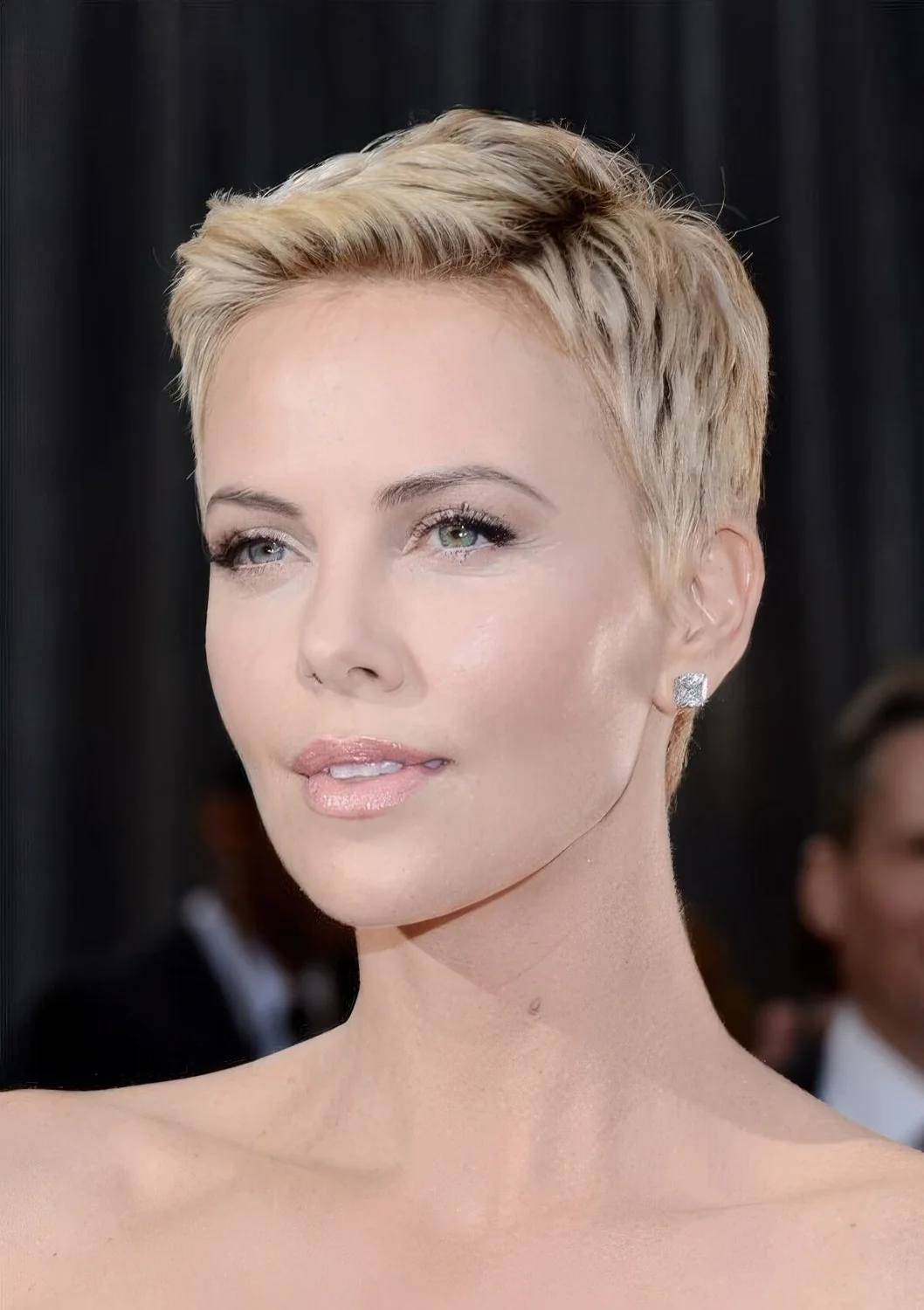 Charlize Theron rocking a chic short blond pixie haircut.