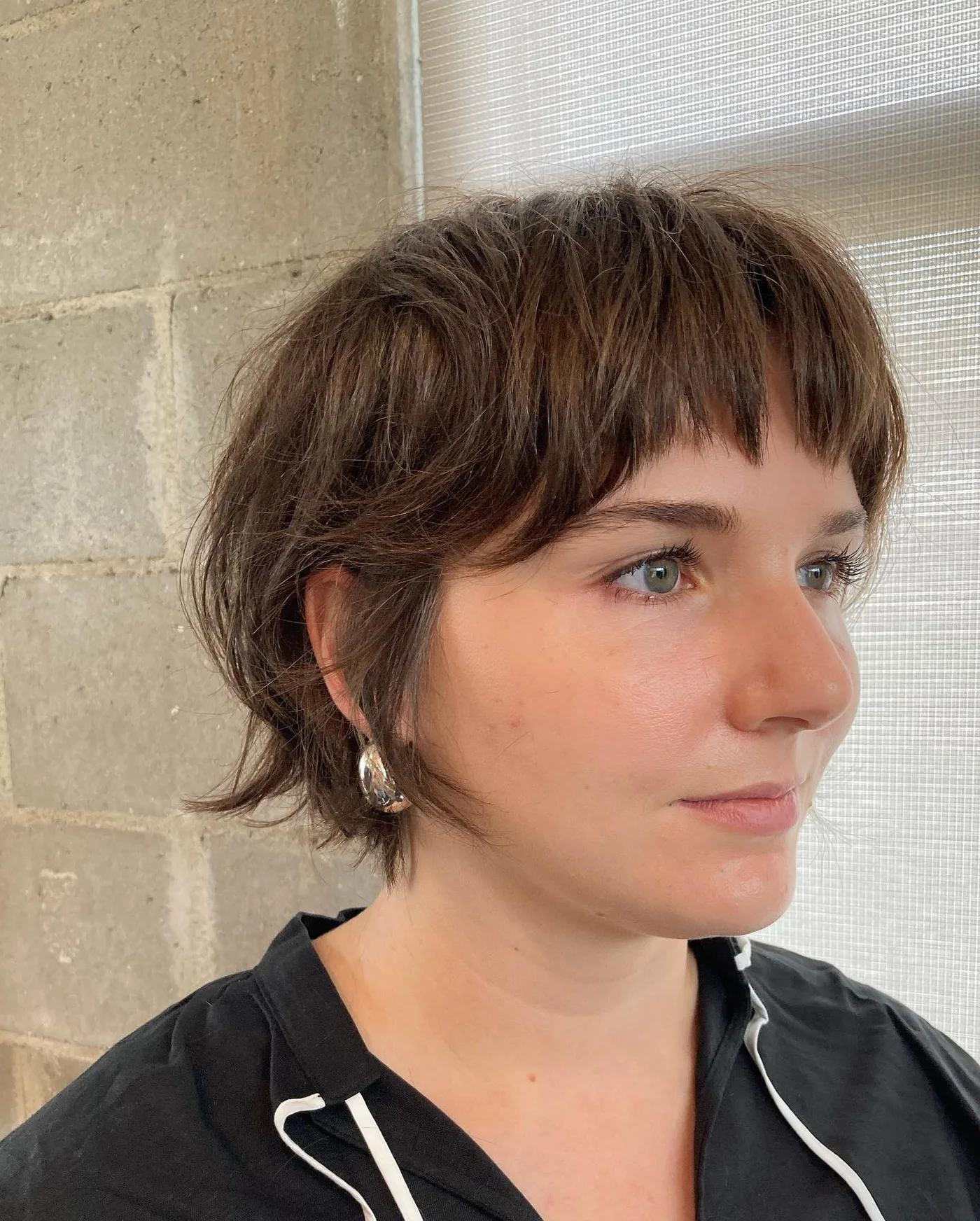 ear wavy brunette shag with micro fringe shown as a short shaggy hair idea