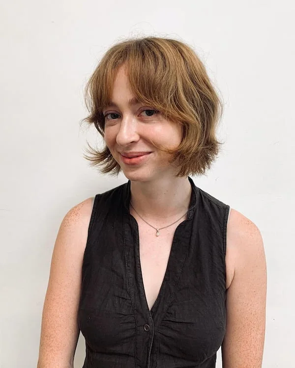 shoulder wavy chestnut shag with curtain fringe shown as a short wolf curtain bangs idea, featuring volume through the all over, shown in blonde shaggy bob with curtain bangs with bob length