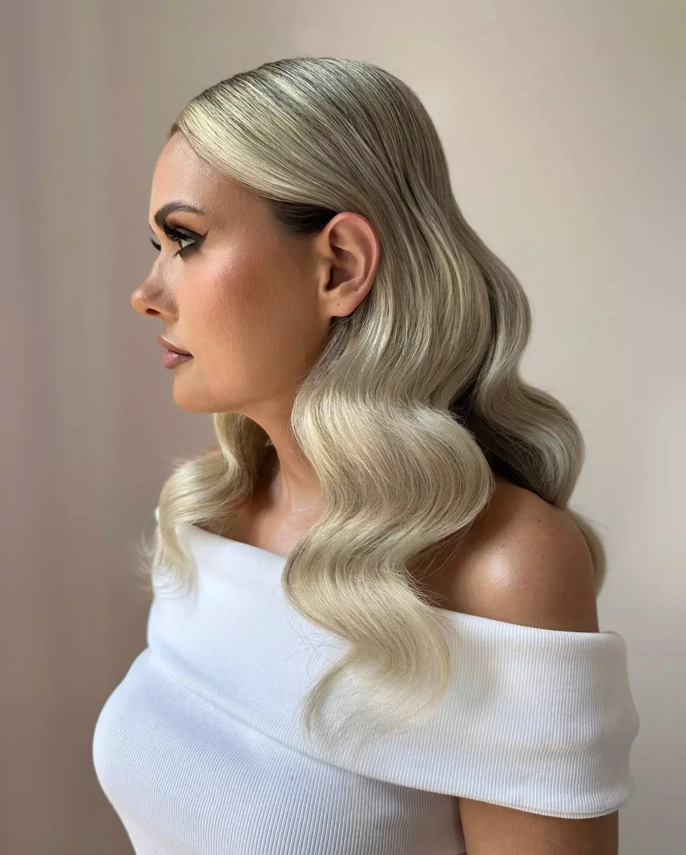 ear wavy blonde pixie with side swept fringe shown as a simple wedding guest hair idea
